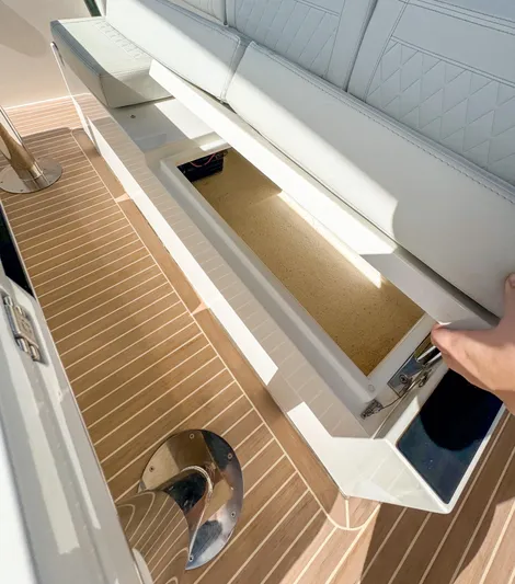  Yacht Photos Pics 2024 De Antonio Yachts D28 Open storage compartment with white seating and wooden flooring.
