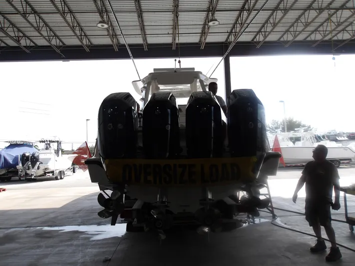  Yacht Photos Pics 2025 SeaVee 420Z boat with multiple engines, marked "Oversize Load," in a covered storage area.