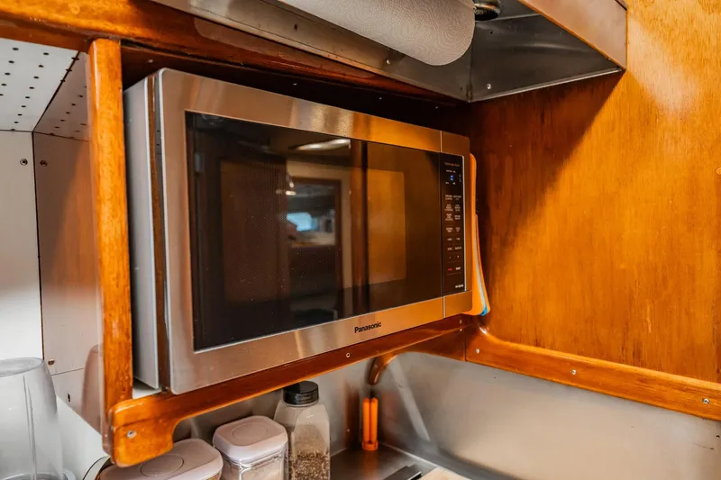 Miss Phebe II Yacht Photos Pics Microwave in wooden cabinet on 1971 Whiticar 62 Convertible boat kitchen.