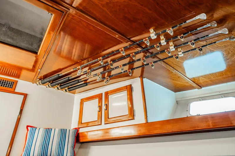 Miss Phebe II Yacht Photos Pics Interior of 1971 Whiticar 62 Convertible with fishing rods on wooden ceiling rack.