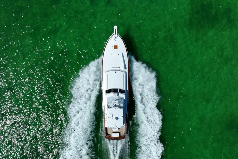 Miss Phebe II Yacht Photos Pics Aerial view of 1971 Whiticar 62 Convertible yacht cruising on vibrant green water.