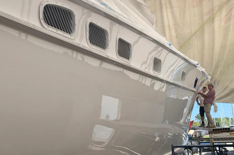 Miss Phebe II Yacht Photos Pics 1971 Whiticar 62 Convertible yacht under maintenance with two people inspecting.