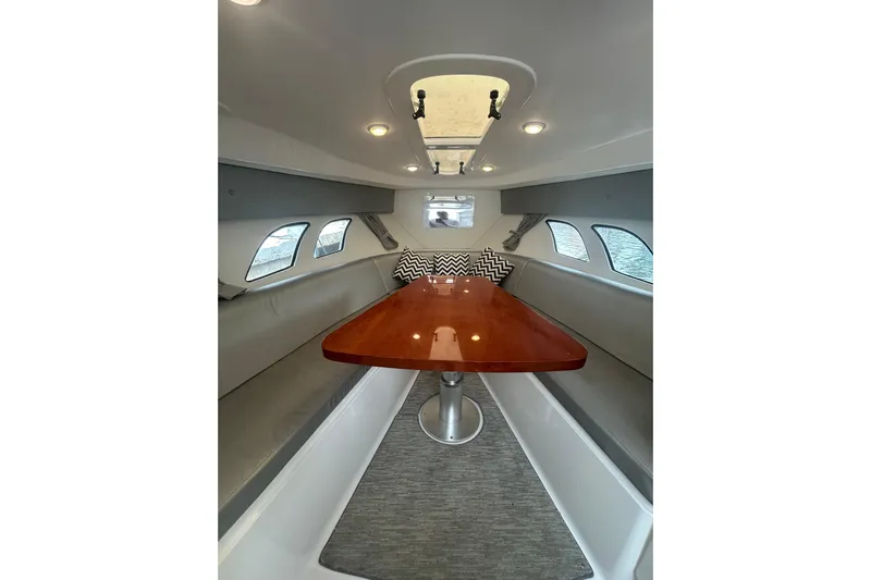  Yacht Photos Pics Interior of 2015 Intrepid 400 Cuddy boat with sleek seating and wooden table.