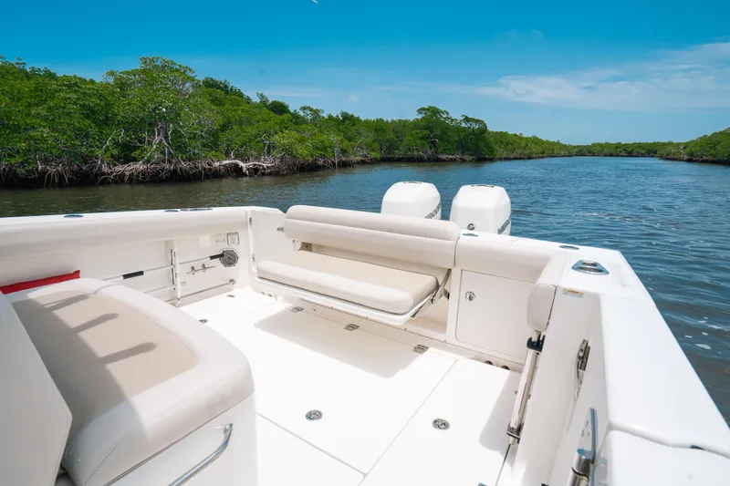 Rock N’ Doc Yacht Photos Pics 2019 Boston Whaler 330 Outrage boat on a serene river with lush greenery.