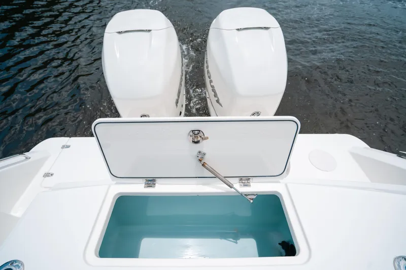 Rock N’ Doc Yacht Photos Pics 2019 Boston Whaler 330 Outrage boat with open storage compartment and twin outboard engines.