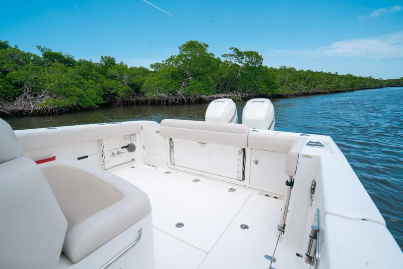 Rock N’ Doc Yacht Photos Pics 2019 Boston Whaler 330 Outrage boat on calm water near lush green mangroves.