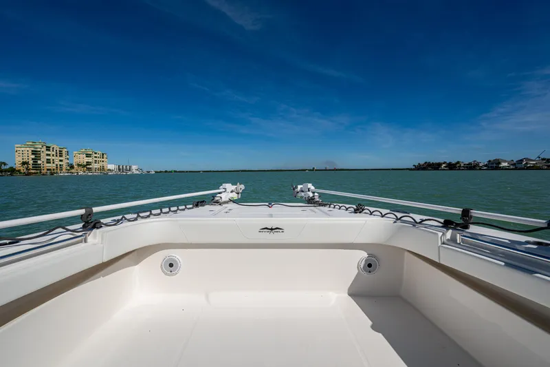 Hoosier Hooker Yacht Photos Pics Invincible 40 Catamaran 2021 on calm waters with coastal buildings in the background.