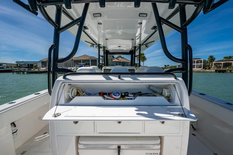 Hoosier Hooker Yacht Photos Pics 2021 Invincible 40 Catamaran interior with storage compartment, docked by waterfront homes.