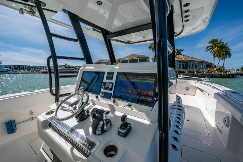 Hoosier Hooker Yacht Photos Pics 2021 Invincible 40 Catamaran helm with modern controls and navigation screens, docked in sunny marina.