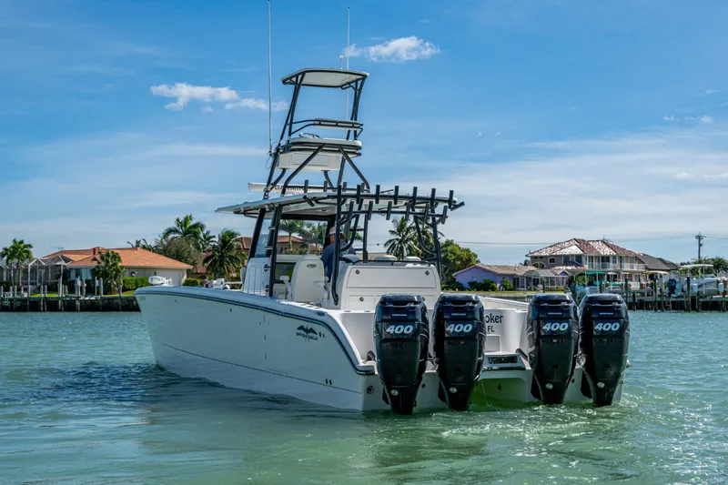 Hoosier Hooker Yacht Photos Pics 2021 Invincible 40 Catamaran with quad engines cruising in a scenic waterfront setting.