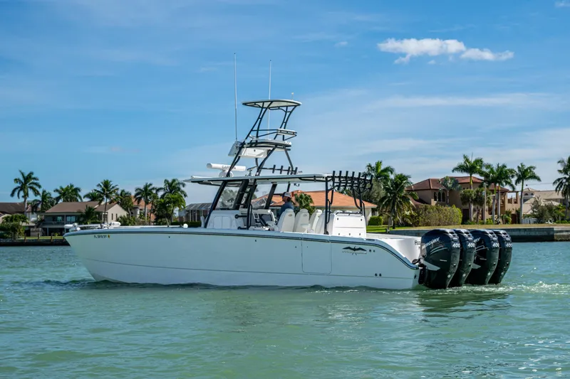 Hoosier Hooker Yacht Photos Pics 2021 Invincible 40 Catamaran on water, with four outboard engines, near waterfront homes.