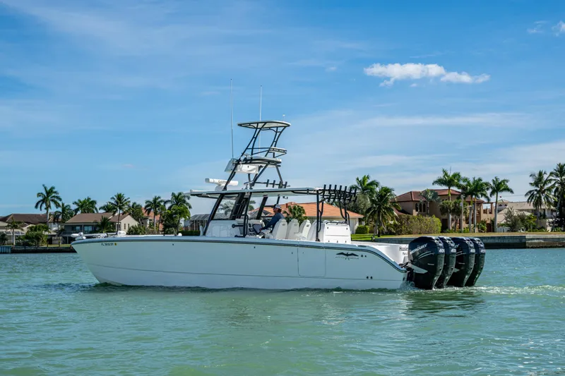 Hoosier Hooker Yacht Photos Pics 2021 Invincible 40 Catamaran on water, featuring multiple outboard engines, with a coastal backdrop.