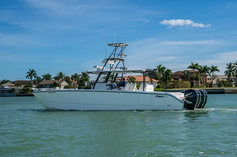 Hoosier Hooker Yacht Photos Pics 2021 Invincible 40 Catamaran cruising on a sunny day near waterfront homes.