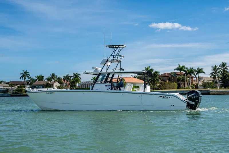 Hoosier Hooker Yacht Photos Pics 2021 Invincible 40 Catamaran cruising on a sunny day near waterfront homes.