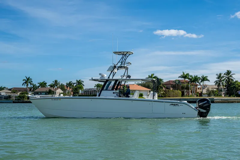 Hoosier Hooker Yacht Photos Pics 2021 Invincible 40 Catamaran cruising on a sunny day near waterfront homes.