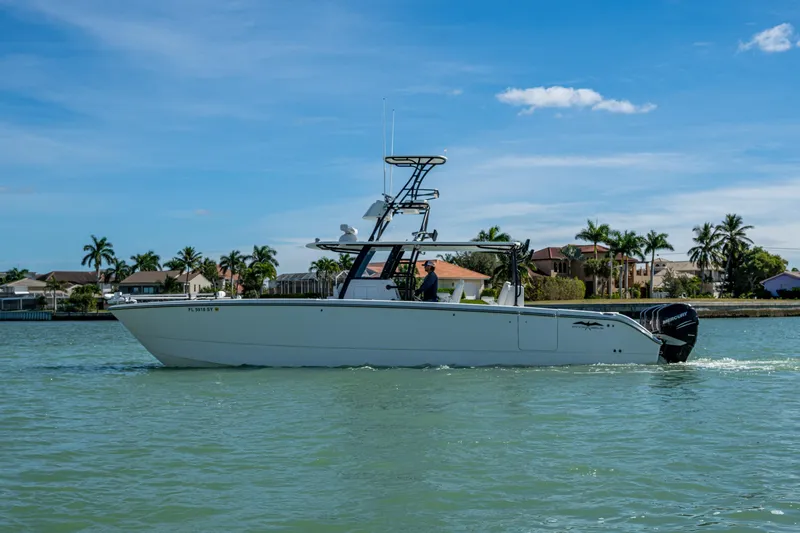 Hoosier Hooker Yacht Photos Pics 2021 Invincible 40 Catamaran cruising on a sunny day near waterfront homes.