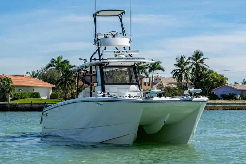 Hoosier Hooker Yacht Photos Pics Invincible 40 Catamaran 2021 on water, with tropical background and clear skies.