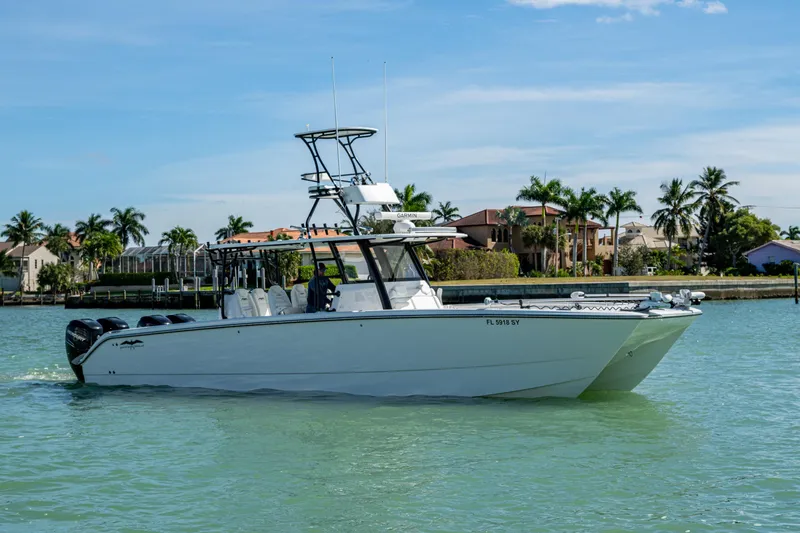 Hoosier Hooker Yacht Photos Pics 2021 Invincible 40 Catamaran cruising on a sunny day near waterfront homes.
