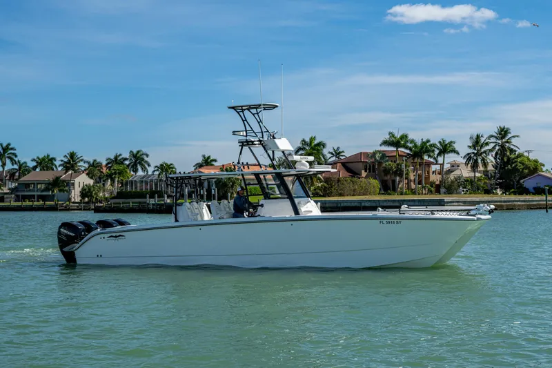 Hoosier Hooker Yacht Photos Pics 2021 Invincible 40 Catamaran cruising on a sunny day near waterfront homes.