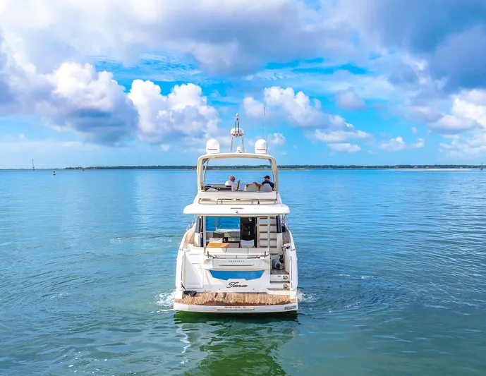 Tara Yacht Photos Pics Luxury yacht Absolute 50 Fly 2017 cruising on calm blue waters under a cloudy sky.