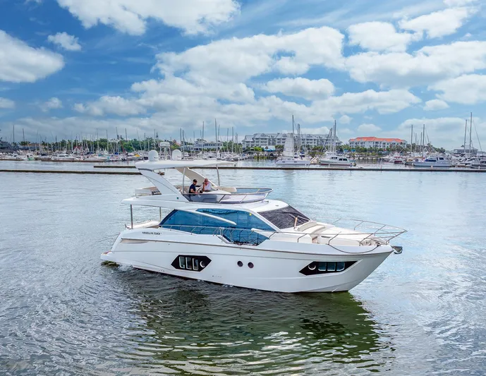 Tara Yacht Photos Pics Luxury 2017 Absolute 50 Fly yacht cruising in a marina under a blue sky.