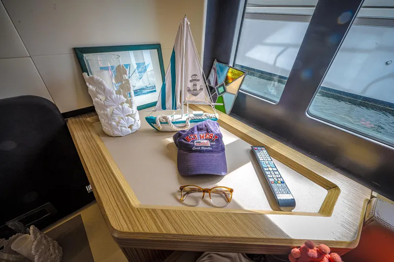 Tara Yacht Photos Pics Cozy yacht interior with decor, remote, and cap on Absolute 50 Fly, 2017 model.