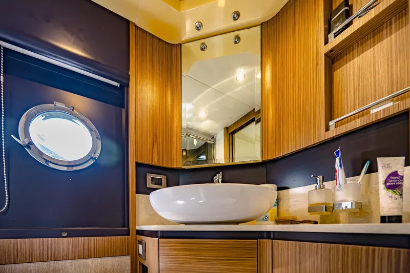 Tara Yacht Photos Pics Luxurious bathroom interior on 2017 Absolute 50 Fly yacht with modern fixtures and porthole window.