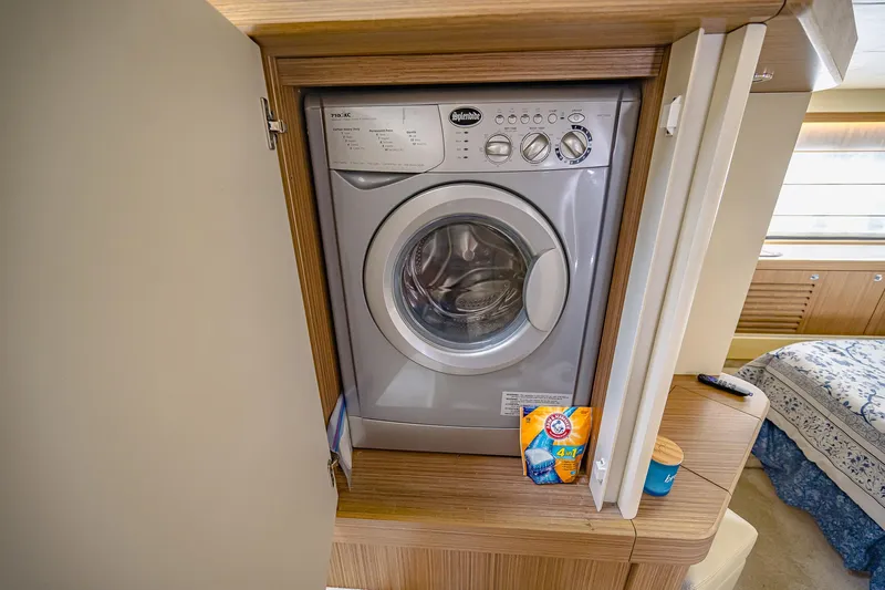 Tara Yacht Photos Pics Washing machine in 2017 Absolute 50 Fly yacht interior, with detergent and fabric softener nearby.