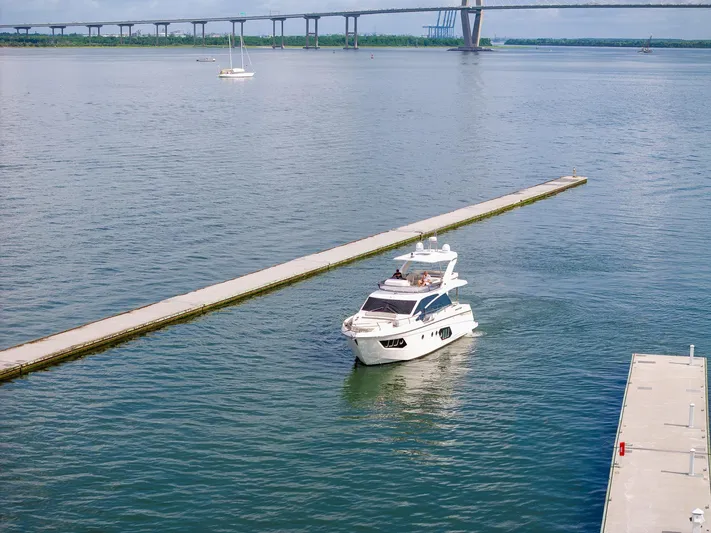 Tara Yacht Photos Pics Luxury yacht Absolute 50 Fly 2017 cruising near a bridge on a calm waterway.