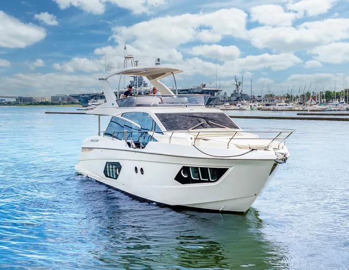 Tara Yacht Photos Pics Luxury 2017 Absolute 50 Fly yacht cruising in a marina under a blue sky.