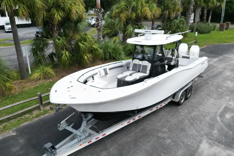 Yacht Photos Pics 2020 Tidewater 320 CC Adventure boat on trailer, surrounded by palm trees.