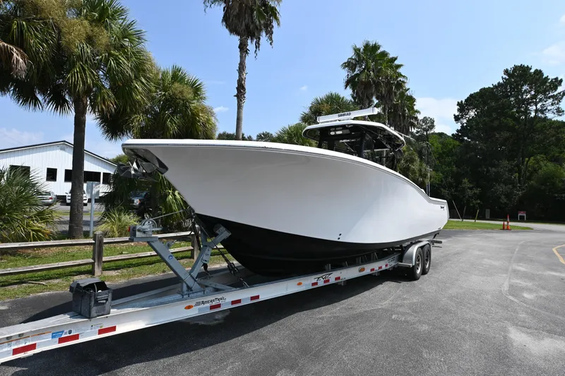  Yacht Photos Pics 2020 Tidewater 320 CC Adventure boat on trailer, surrounded by palm trees.