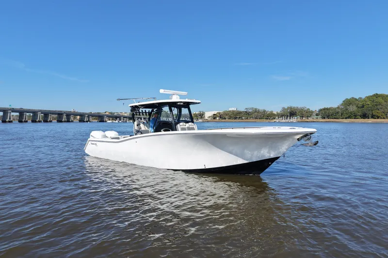  Yacht Photos Pics 2020 Tidewater 320 CC Adventure boat on calm water, clear sky background.