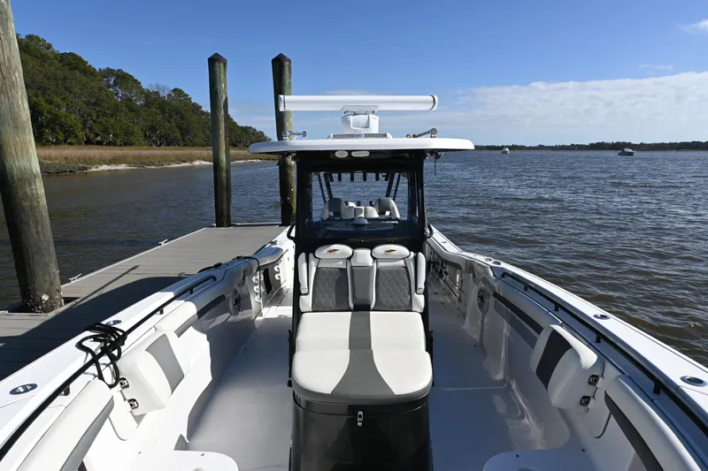  Yacht Photos Pics 2020 Tidewater 320 CC Adventure boat docked by a serene waterfront.