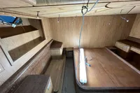 Interior of 2023 Custom KAITOS 68 yacht with wooden furnishings and ambient lighting.