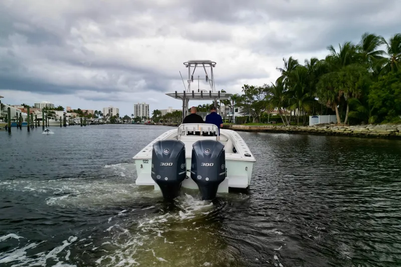 Ribeye Yacht Photos Pics 2005 Jupiter 31 Center Console boat cruising on a scenic waterway with palm trees.