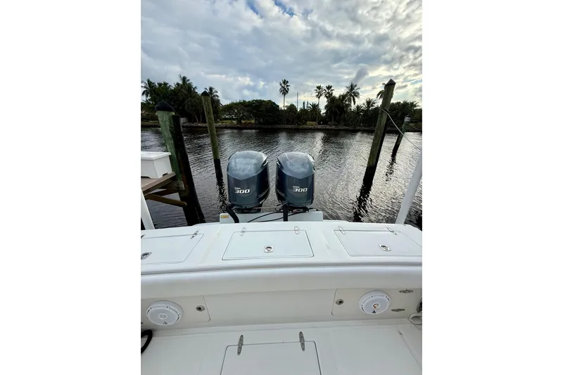 Ribeye Yacht Photos Pics 2005 Jupiter 31 Center Console boat with twin 300 horsepower engines docked by a scenic waterfront.