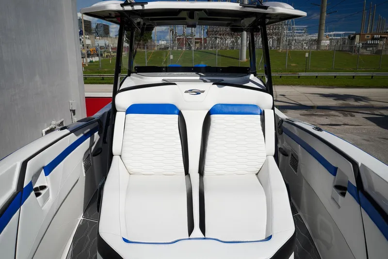 Never Enough Yacht Photos Pics 2023 Sunsation 32 CCX boat interior with white and blue seating, modern design.