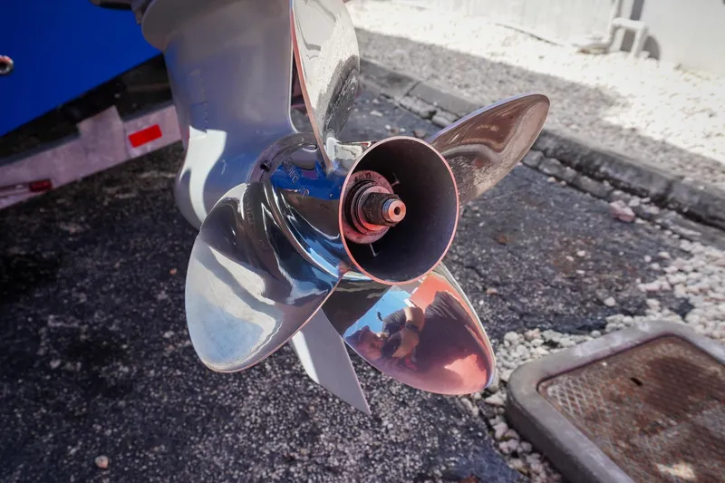 Never Enough Yacht Photos Pics Close-up of a 2023 Sunsation 32 CCX boat propeller on pavement.