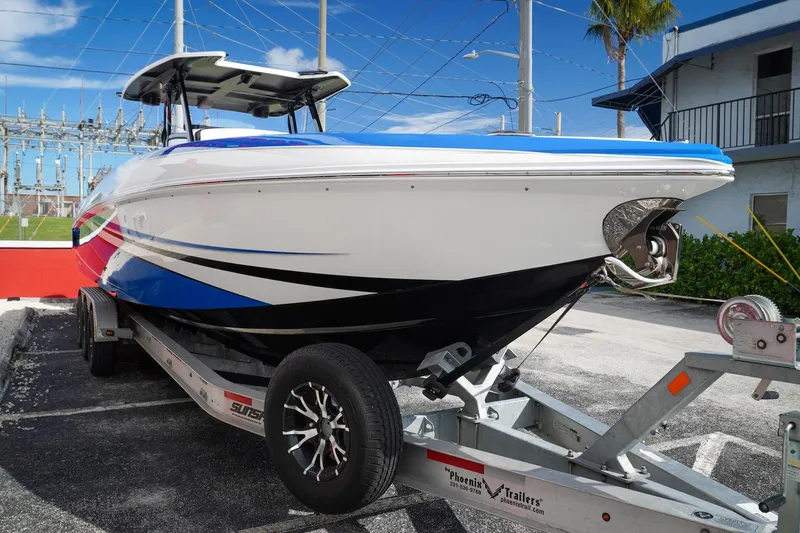 Never Enough Yacht Photos Pics 2023 Sunsation 32 CCX boat on trailer, vibrant design, parked outdoors.