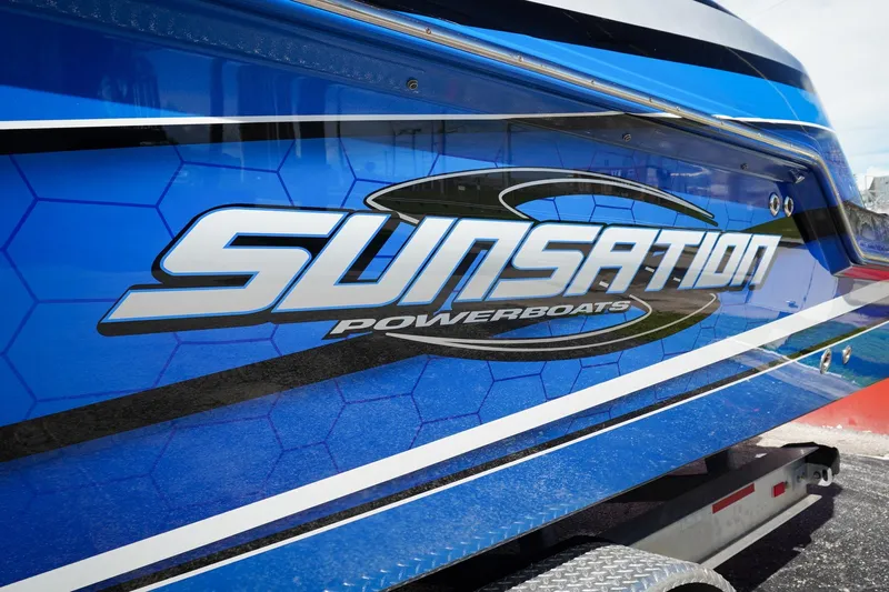 Never Enough Yacht Photos Pics 2023 Sunsation 32 CCX powerboat with blue hexagonal design and bold logo.