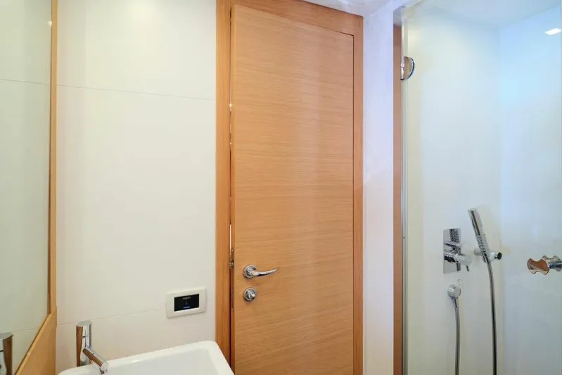 Nickel Yacht Photos Pics Bathroom interior of 2008 Pershing 64 yacht with modern fixtures and wooden door.