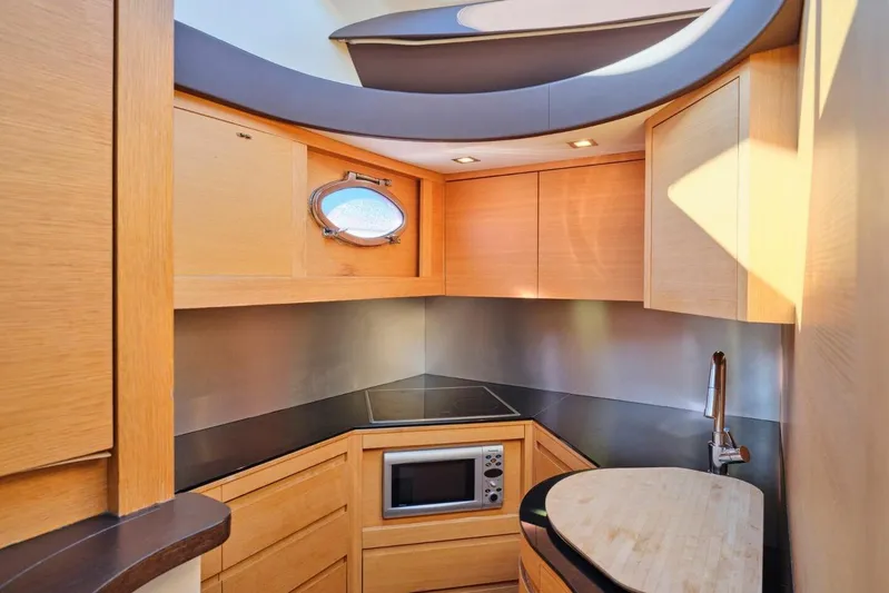 Nickel Yacht Photos Pics Luxurious 2008 Pershing 64 yacht kitchen with modern appliances and sleek wooden cabinetry.