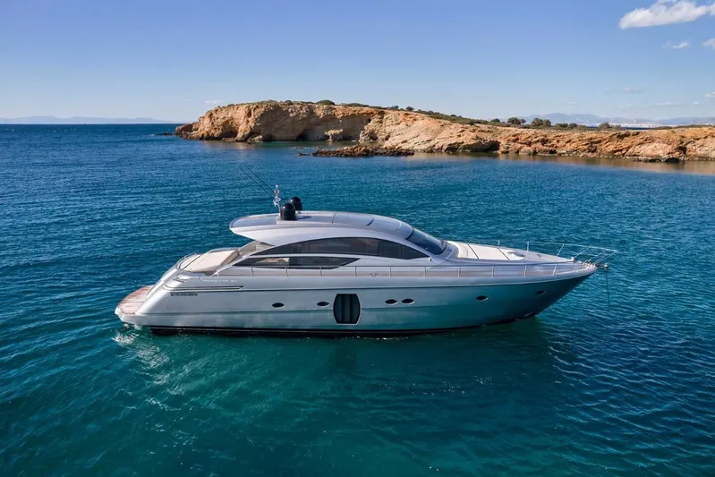 Nickel Yacht Photos Pics 2008 Pershing 64 yacht cruising in clear blue waters near rocky coastline.