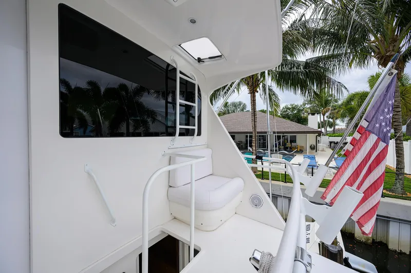  Yacht Photos Pics 2008 Viking 56 Enclosed Bridge yacht with American flag, docked near palm trees.