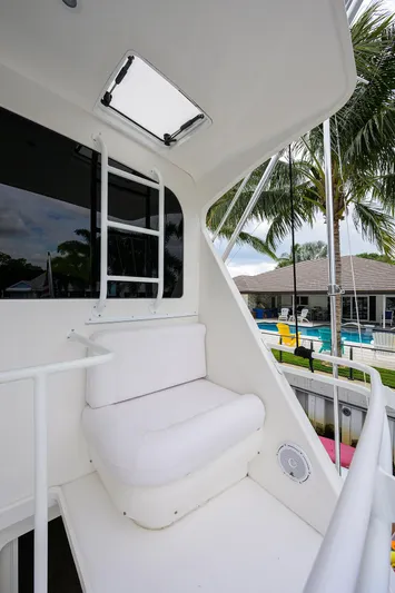  Yacht Photos Pics 2008 Viking 56 Enclosed Bridge yacht with white seating and ladder, near a poolside.