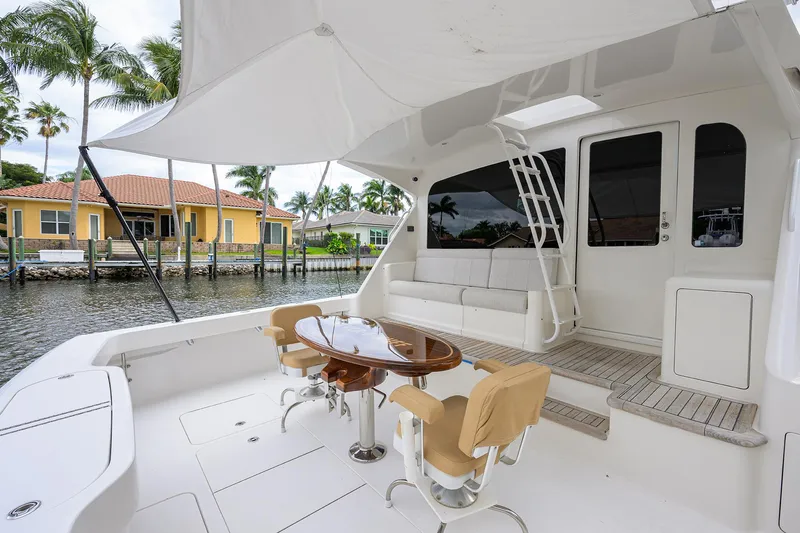  Yacht Photos Pics 2008 Viking 56 Enclosed Bridge yacht with outdoor seating and table, docked by waterfront homes.