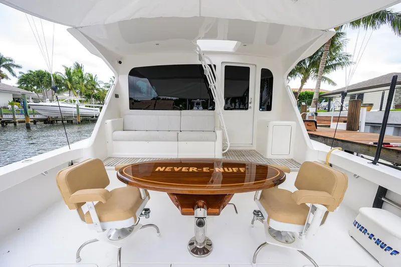  Yacht Photos Pics 2008 Viking 56 Enclosed Bridge yacht with elegant seating and table, docked by palm trees.