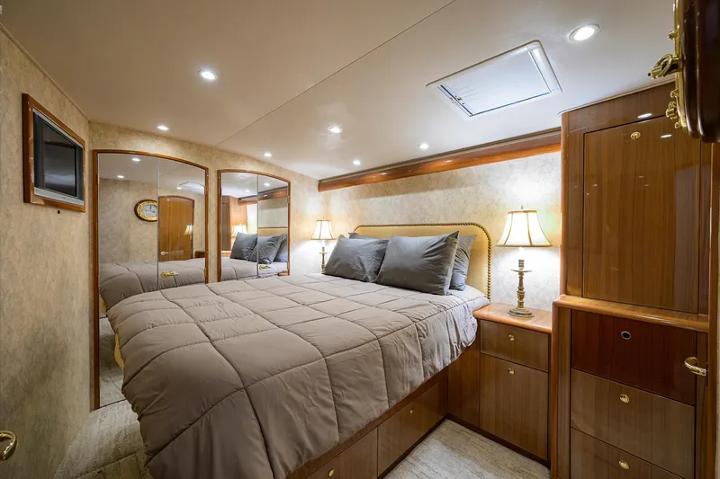  Yacht Photos Pics Luxurious bedroom interior of 2008 Viking 56 Enclosed Bridge yacht with elegant wood finishes.