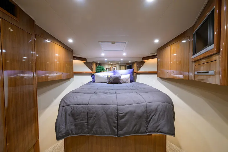  Yacht Photos Pics Luxurious bedroom interior of 2008 Viking 56 Enclosed Bridge yacht with wood paneling.